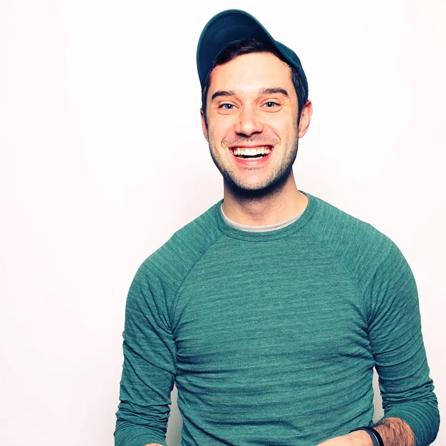 Mike Weslander, smiling, in a cap and a teal sweater.